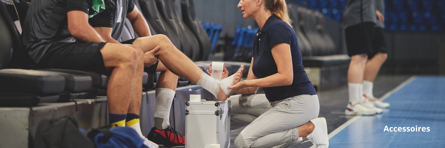 Soignante appliquant un bandage à un joueur assis sur un banc pendant un match, illustrant l'utilisation rapide d'accessoires de premiers soins sur le terrain.
